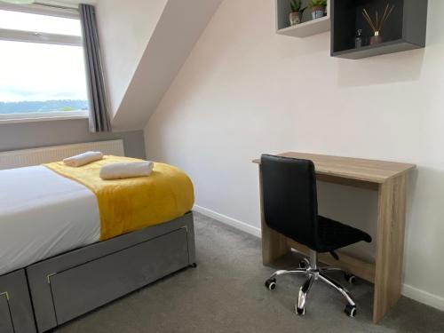 a bedroom with a bed and a desk and a chair at Cosy room Maidstone in Kent