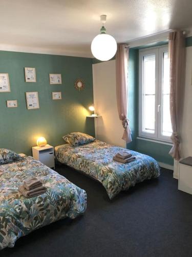 une chambre d'hôtel avec deux lits et une fenêtre dans l'établissement La voyageuse, gîte 6 places, à Pluvigner