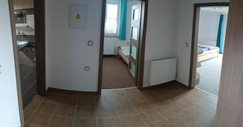 a room with a hallway with a mirror and a bathroom at Apartmány U Srdce Vltavy in Horní Planá