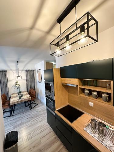 a kitchen with black cabinets and a dining room at Holiday Flat in Liptovský Mikuláš