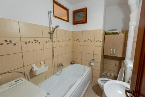 a bathroom with a tub and a toilet and a sink at Park apartman - központi, csendes, családbarát in Odorheiu Secuiesc