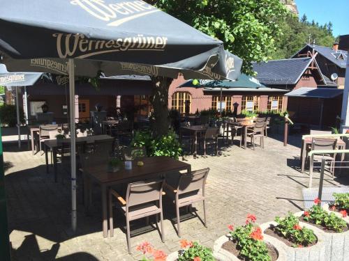 a patio with tables and chairs and umbrellas at Hotel am Berg Oybin garni in Kurort Oybin