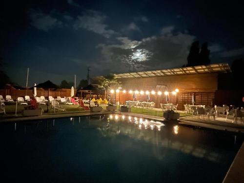 a swimming pool at night with the moon in the background at Hotel Santo Stefano in Campagnola Emilia