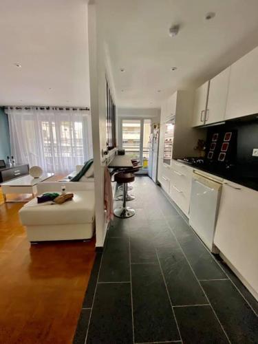 un salon avec un canapé blanc et une cuisine dans l'établissement CHAMBRE DE 11 M2 AVEC BALCON, à Paris