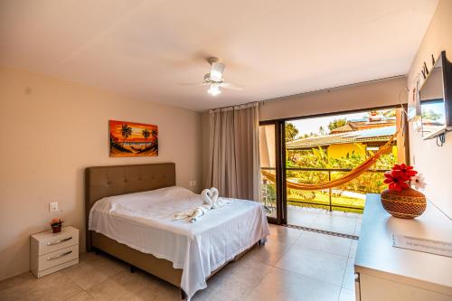 a bedroom with a bed and a balcony at Chales Maragogi in Maragogi