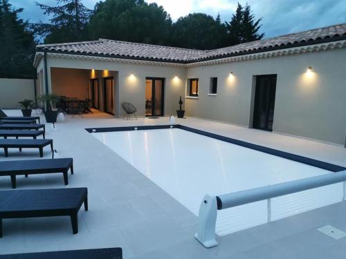 una gran piscina con sillas alrededor en GRAND GîTE AUGUSTA, en Ruoms