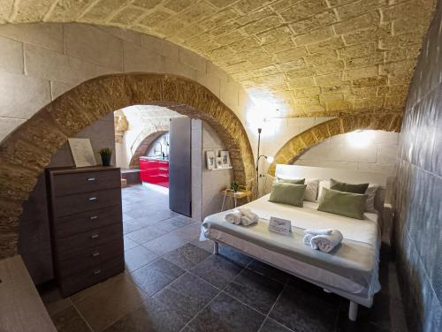 een slaapkamer met een bed in een stenen muur bij L'otto in Mesagne