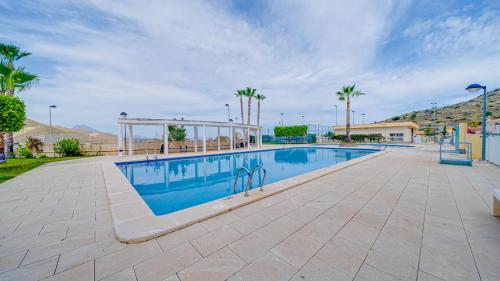 a swimming pool at a resort with palm trees at Piso en El Poblet 3 dormitorios in El Campello