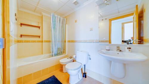 a bathroom with a toilet and a sink and a tub at Piso en El Poblet 3 dormitorios in El Campello