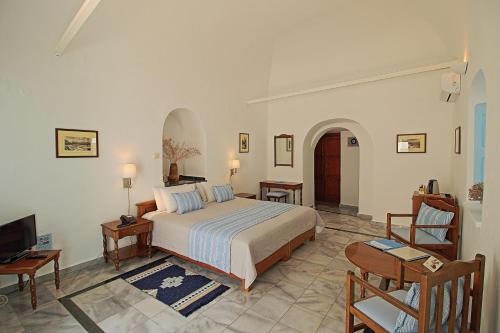 a bedroom with a bed and a tv in it at Aethrio Sunset Village - Oia in Oia