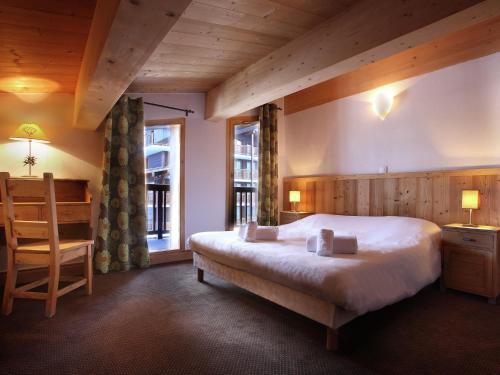 1 dormitorio con cama, escritorio y silla en Modern apartment located in the extensive Paradiski ski area, en Arc 2000