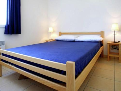 une chambre avec un grand lit avec des draps bleus dans l'établissement Apartment in Carcans near Sandy Beach, à Carcans