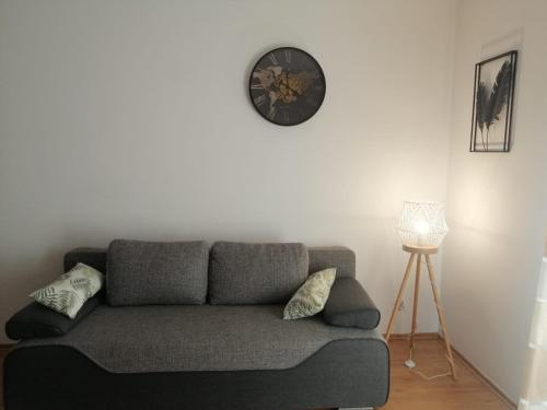 a living room with a couch and a clock on the wall at Tylko dla Orłów in Warsaw