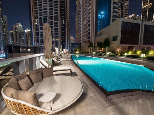 a swimming pool with lounge chairs and aituresasteryasteryasteryasteryasteryasteryastery at Luxury 3BR with Burj Khalifa Views, Pool, Gym, and Free Parking in Dubai