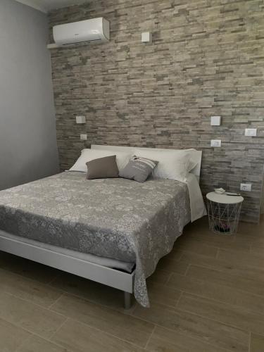1 dormitorio con cama y pared de ladrillo en B&B La Limonaia, en Tollo
