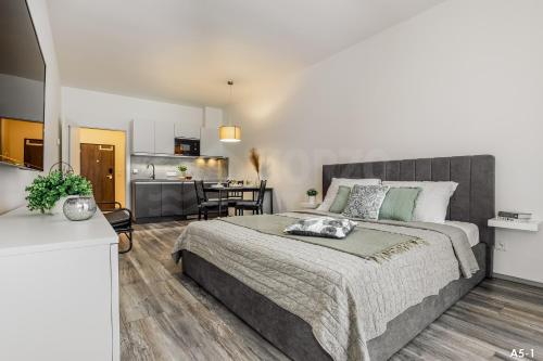 a bedroom with a large bed and a kitchen at KORZO LIPNO 2 in Lipno nad Vltavou