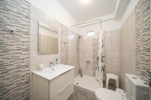 biała łazienka z umywalką i toaletą w obiekcie Villa Elaionas 2 in Svoronata! w mieście Svoronata
