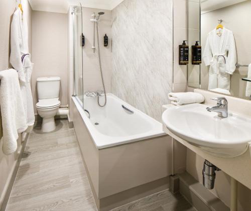 a bathroom with a sink and a tub and a toilet at Mercure Manchester Piccadilly Hotel in Manchester