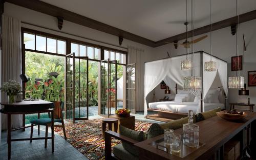 a bedroom with a bed and a living room with a table at La Reserve 1785 Canggu Beach in Canggu