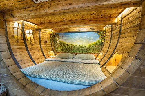 a circular bed in a wooden room with a window at Hotel Kocourkov in Hlinsko
