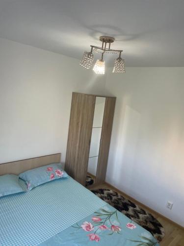 a bedroom with a bed and a chandelier at Apartament NEPTUN in Neptun