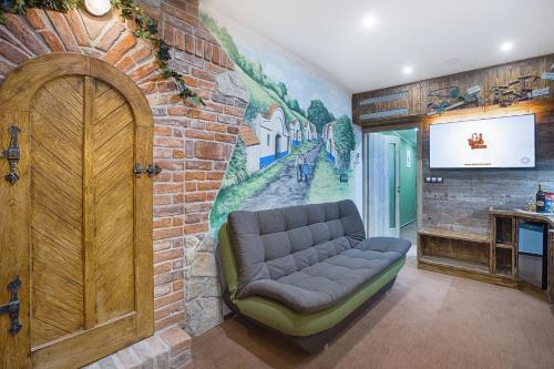 a living room with a couch against a brick wall at Hotel Kocourkov in Hlinsko