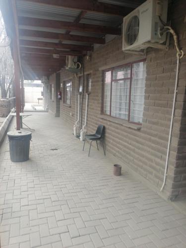 a patio with a chair sitting next to a brick wall at Kwagga lodge in Bloemfontein