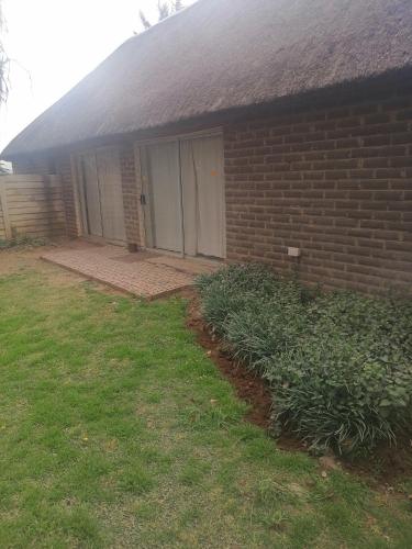 a brick house with a door and a yard at Kwagga lodge in Bloemfontein