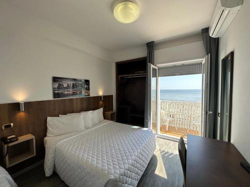 a bedroom with a bed and a view of the ocean at Hotel Centrale in Milano Marittima