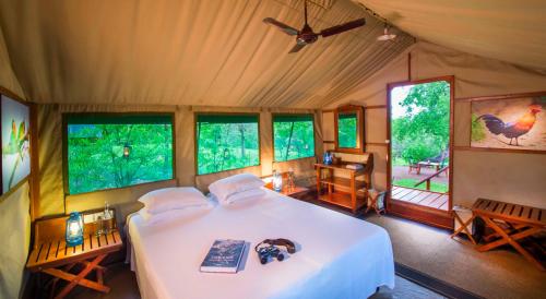 a bedroom with a bed in a room with windows at Kulu Safaris - All Inclusive in Yala