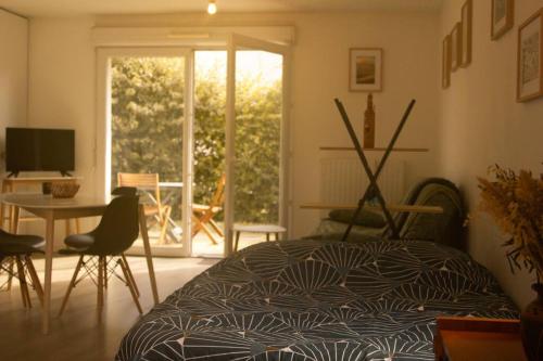 una camera con letto, tavolo e finestra di Studio le Flamboyant a Cholet