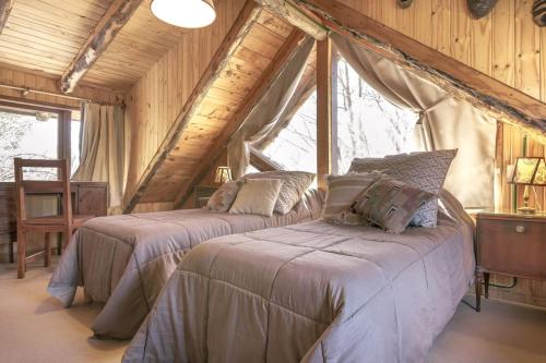 a bedroom with two beds in a attic at Pai Pay Calido y Confortable Bungalow in San Carlos de Bariloche