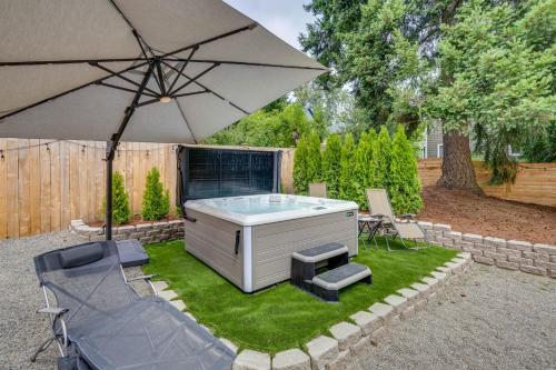 a hot tub with two chairs and an umbrella at Kenmore Retreat with Shared Hot Tub - 1 Mi to Lake! in Kenmore