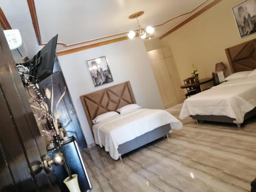 a bedroom with two beds and a flat screen tv at Macacona Hacienda Hotel in Ica