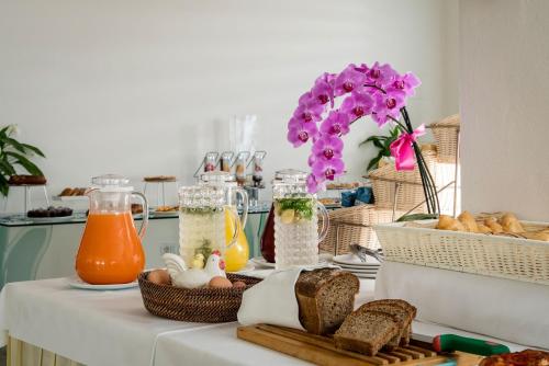 - une table avec du pain et des pots de jus d'orange dans l'établissement Hotel delle Nazioni, à Pesaro