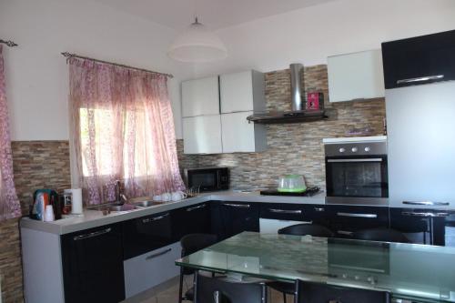 a kitchen with black and white cabinets and a table at Pi la via di Selinunte in Partanna
