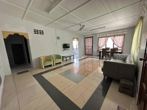 - un grand salon avec un canapé et une table dans l'établissement Warisan Homestay B, à Mersing