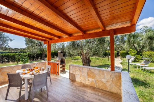 a patio with a table and chairs under a wooden pergola at Agriturismo I Tesori del Sud Vieste, Puglia in Vieste