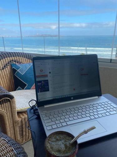 a laptop computer sitting on a table in front of a window at Sobre línea de Playa, Maravillosa Vista al mar 2B/2B-Wifi-TV70´Netf- Estacionamiento propio in La Serena