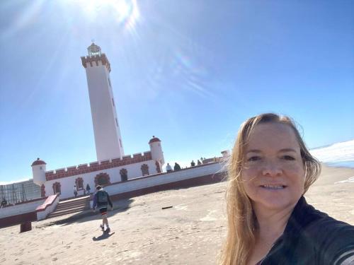 a woman standing in front of a lighthouse at Sobre línea de Playa, Maravillosa Vista al mar 2B/2B-Wifi-TV70´Netf- Estacionamiento propio in La Serena
