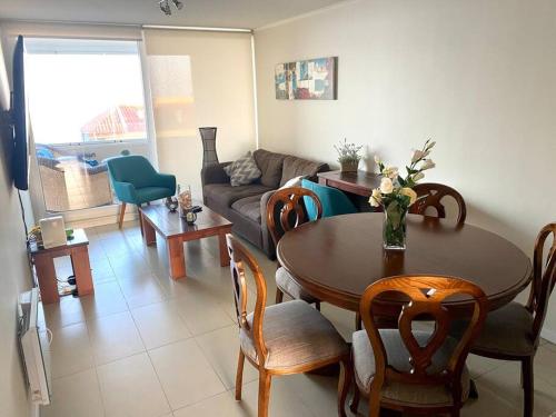 a living room with a table and chairs and a couch at Sobre línea de Playa, Maravillosa Vista al mar 2B/2B-Wifi-TV70´Netf- Estacionamiento propio in La Serena
