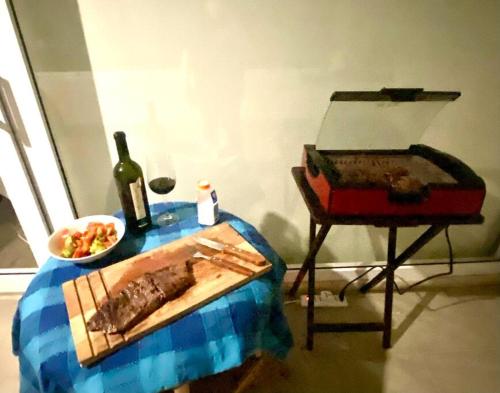 a table with a plate of food and a bottle of wine at Sobre línea de Playa, Maravillosa Vista al mar 2B/2B-Wifi-TV70´Netf- Estacionamiento propio in La Serena