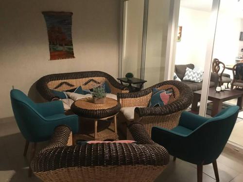 a living room with wicker chairs and a table at Sobre línea de Playa, Maravillosa Vista al mar 2B/2B-Wifi-TV70´Netf- Estacionamiento propio in La Serena