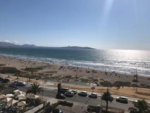 a beach with a lot of people and the ocean at Sobre línea de Playa, Maravillosa Vista al mar 2B/2B-Wifi-TV70´Netf- Estacionamiento propio in La Serena