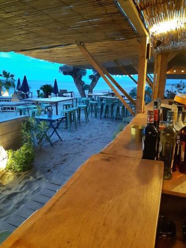 - un bar en bois avec des bouteilles de vin sur la plage dans l'établissement Maison de maître dans le village, bord de mer, à Torreilles