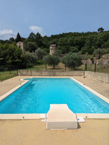 - une grande piscine avec une chaise longue à côté dans l'établissement Mas du Bosc, à Rosières