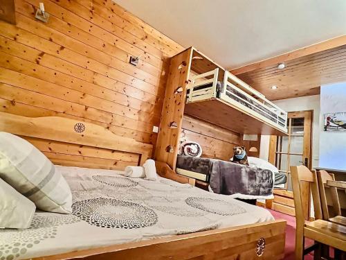 - une chambre avec un lit et un mur en bois dans l'établissement Studio chaleureux proche centre et pistes, Val d'Isère - FR-1-411-200, à Val dʼIsère