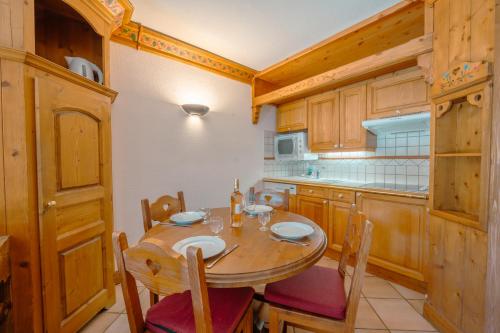 - une cuisine avec une table et des chaises en bois dans la chambre dans l'établissement Résidence Le Cristal - Mont Blanc 5 - Happy Rentals, à Chamonix-Mont-Blanc
