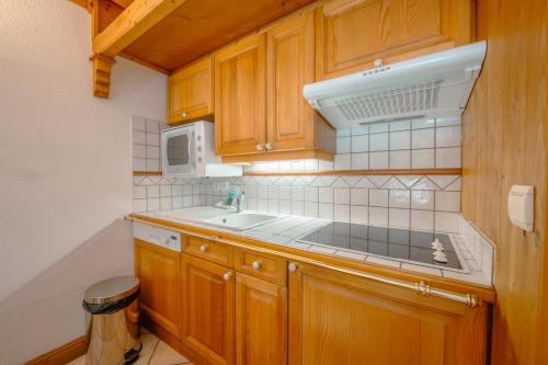 une cuisine avec un évier et un micro-ondes dans l'établissement Résidence Le Cristal - Mont Blanc 5 - Happy Rentals, à Chamonix-Mont-Blanc