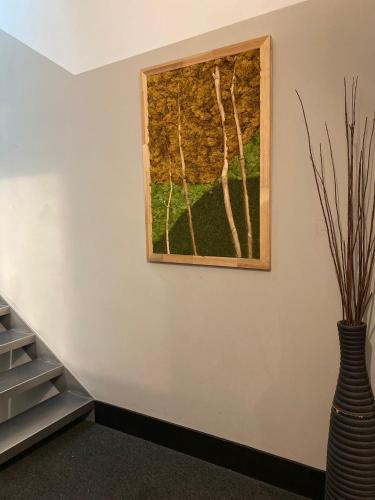a painting of trees on a wall next to a vase at MH Design Hotel in Naples